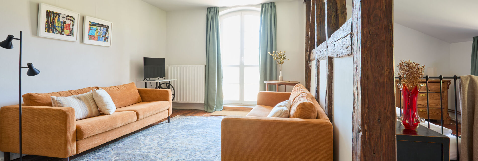 Das Wohnzimmer im Apartment Marie mit Kamin, gemütlichen Sofas und Zugang zur Terrasse Gut Pohnstorf/Andrea Girard