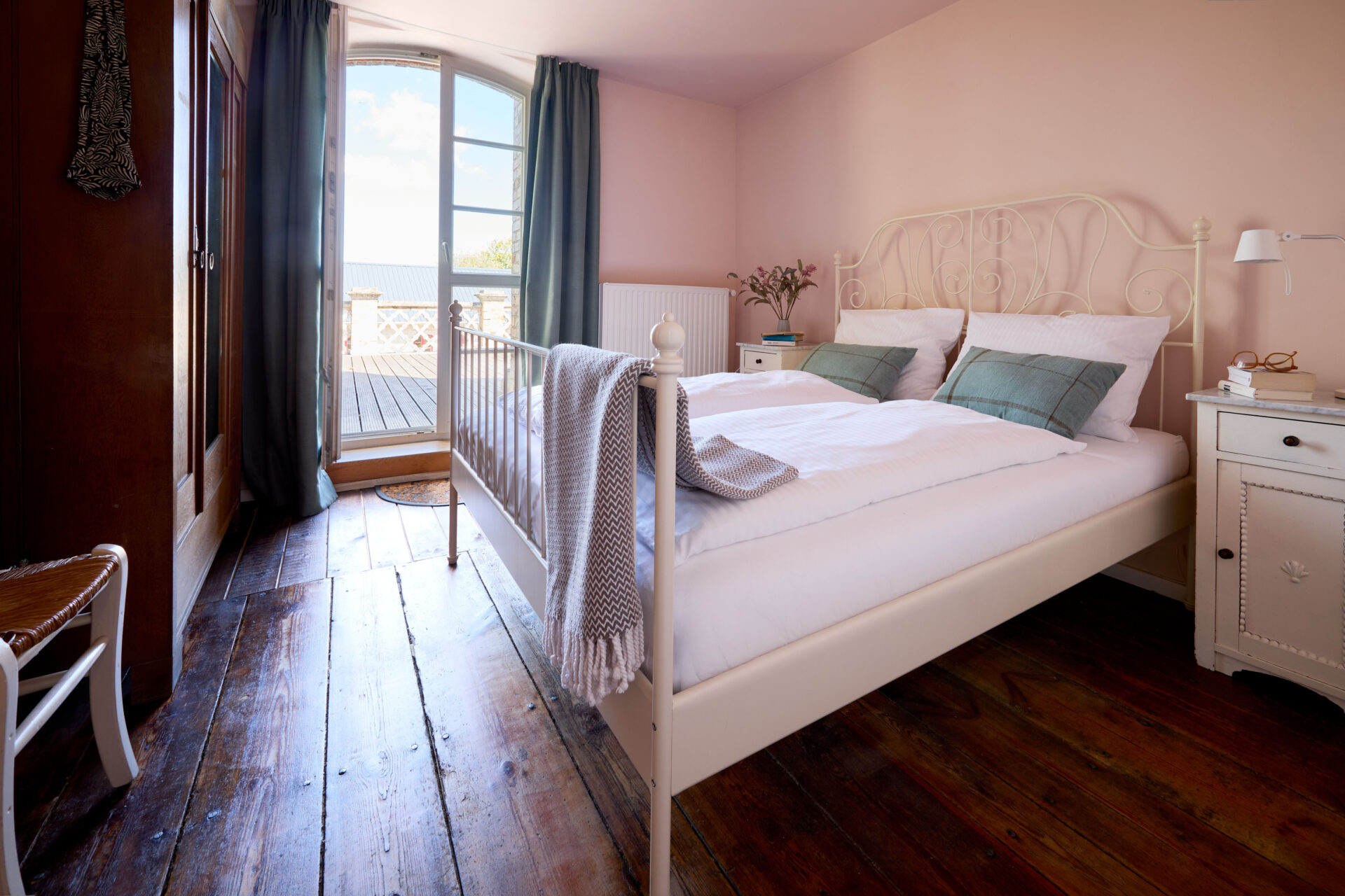 Schlafzimmer mit Doppelbett und Zugang zur Terrasse in der Wohnung Marie Gut Pohnstorf/Andrea Girard