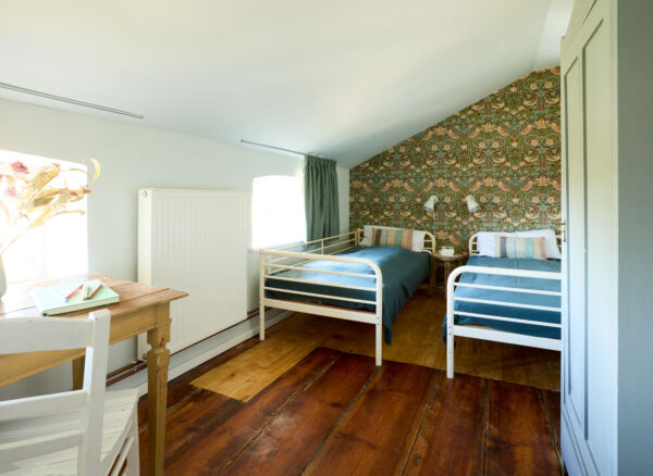 Schlafzimmer mit zwei Einzelbetten Schreibtisch im Apartment Marie Gut Pohnstorf/Andrea Girard